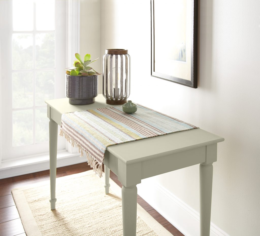 A small rectangular table painted in a light grey-green colour