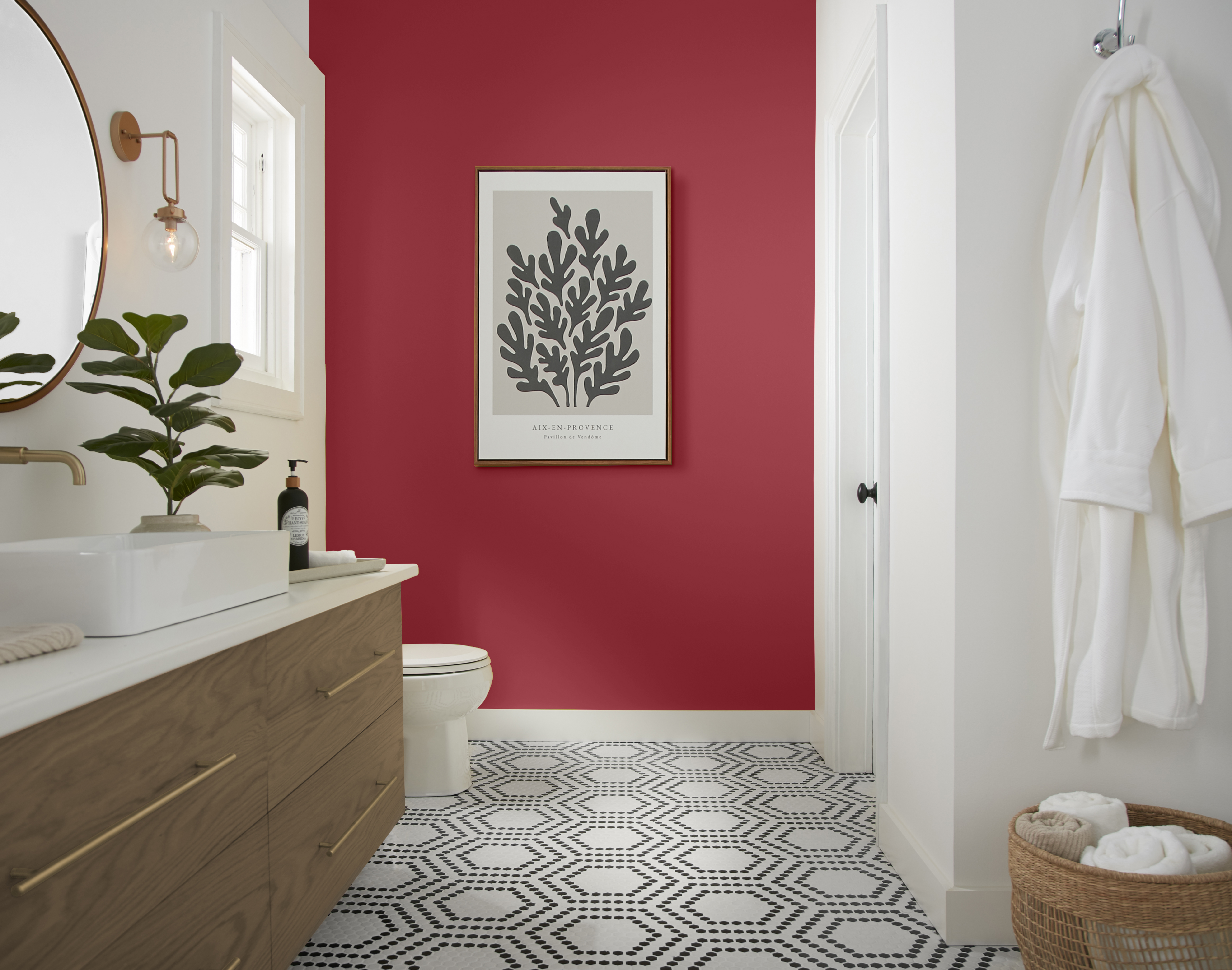 A bright white bathroom with a vibrant red accent wall.