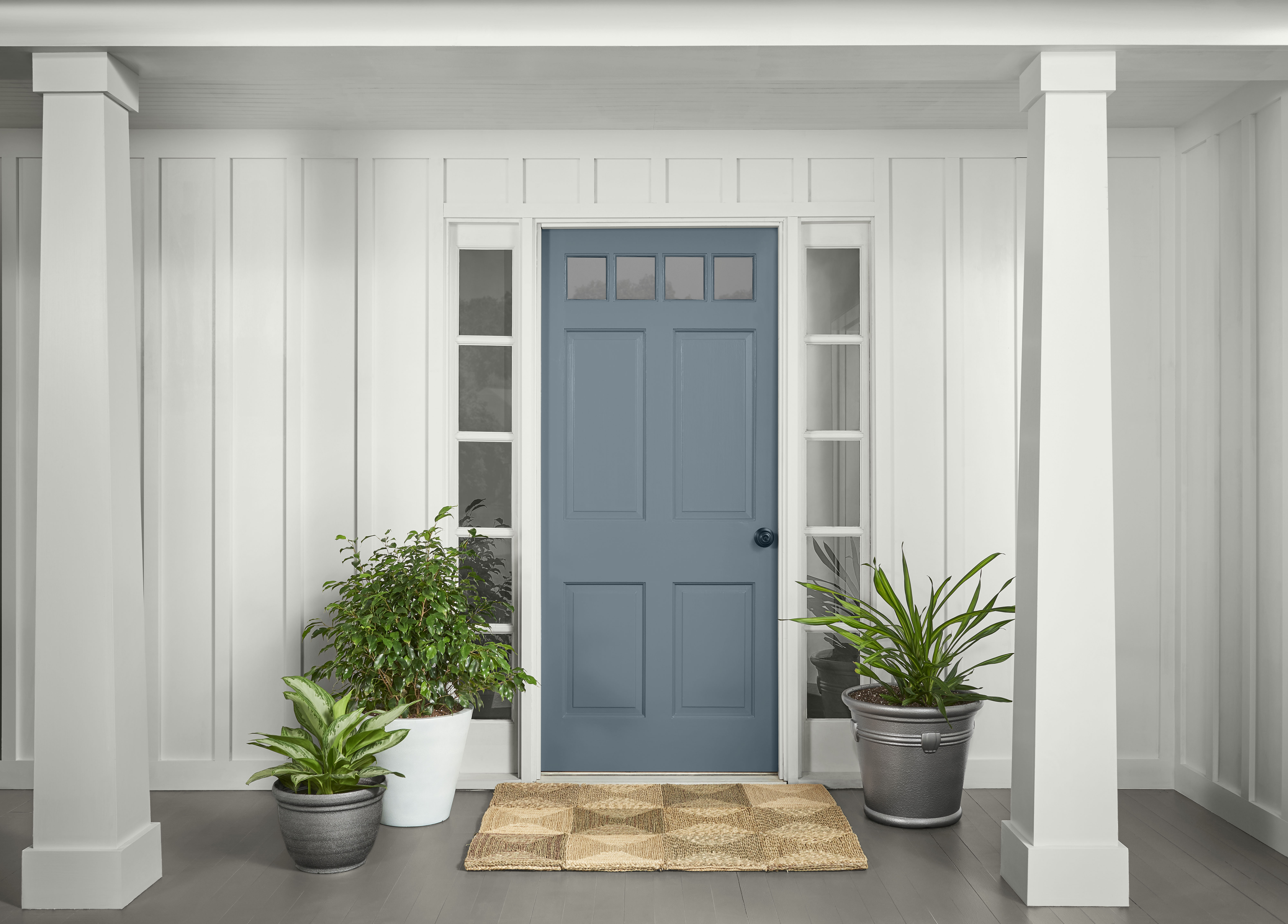 A front porch with a blue door centered between two white columns