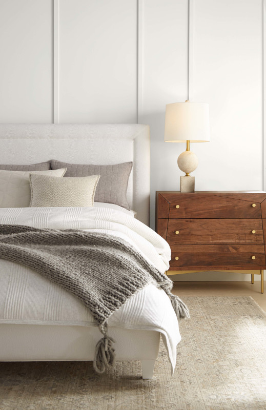 A contemporary bedroom with a comfortable bed, the walls feature an ever so slightly yellow-toned white, adding a warm and inviting touch to the space.