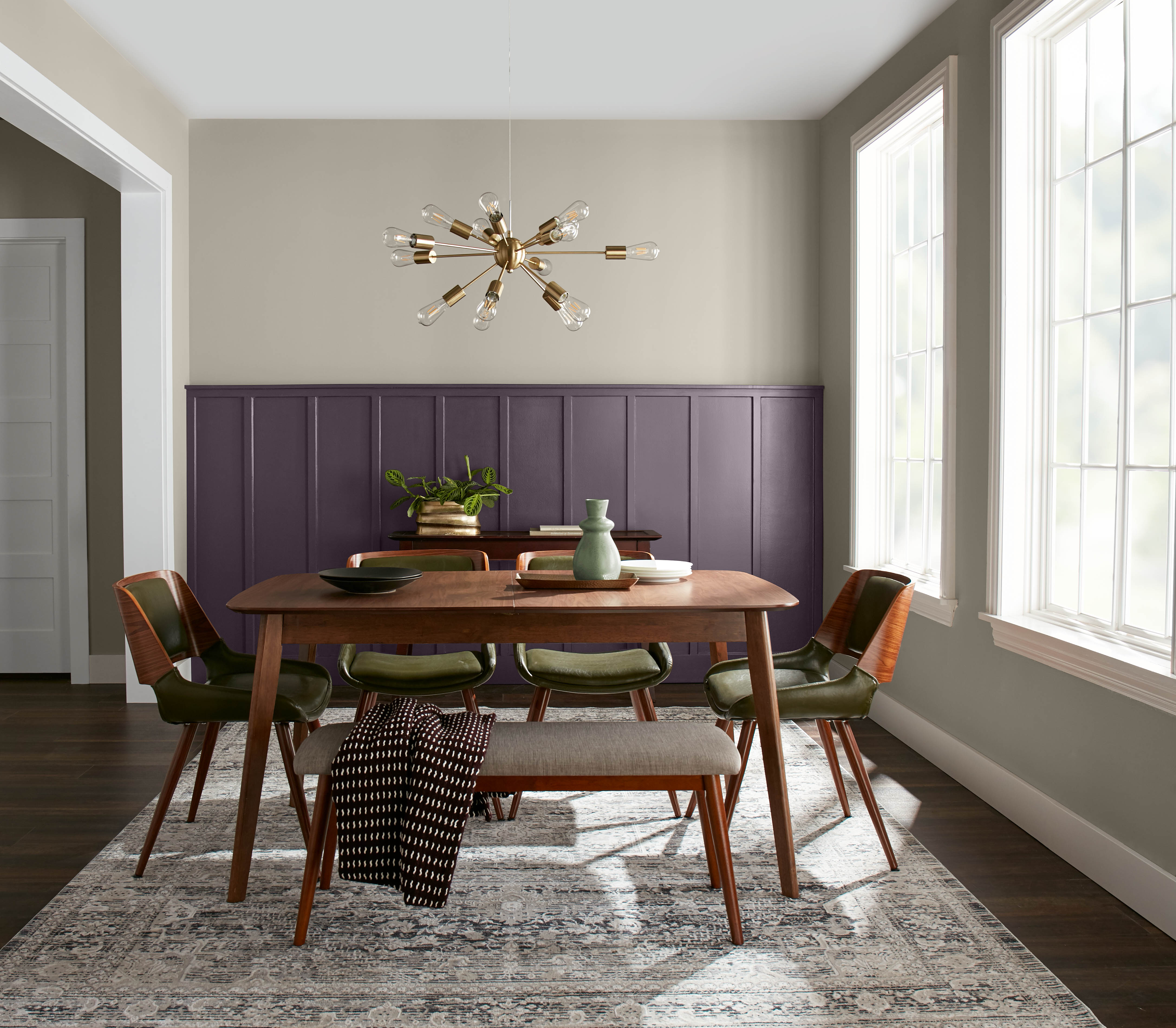 A dining room with a deep purple accent wall surrounded by neutral hues.