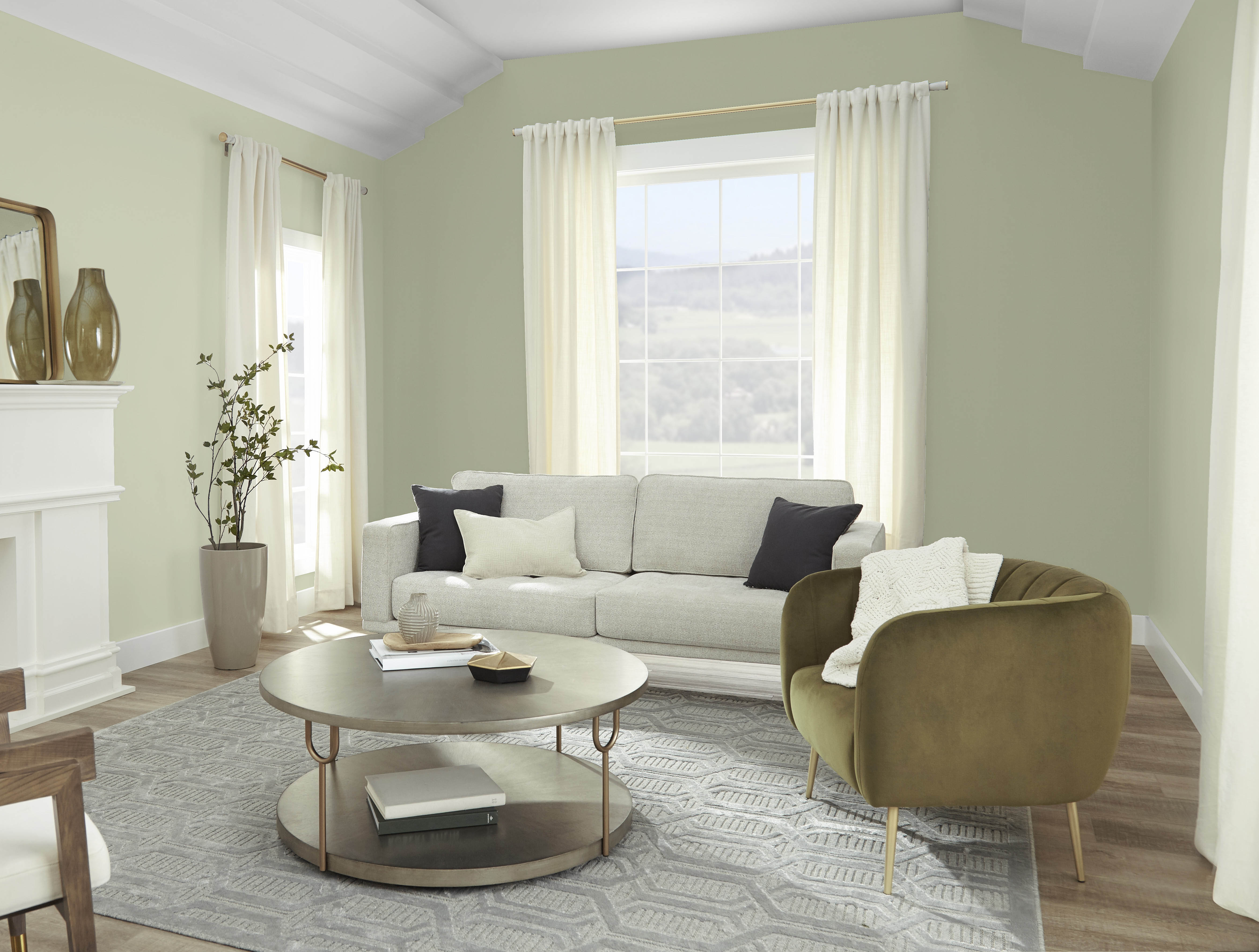 A living room with walls painted in a soft muted green hue.