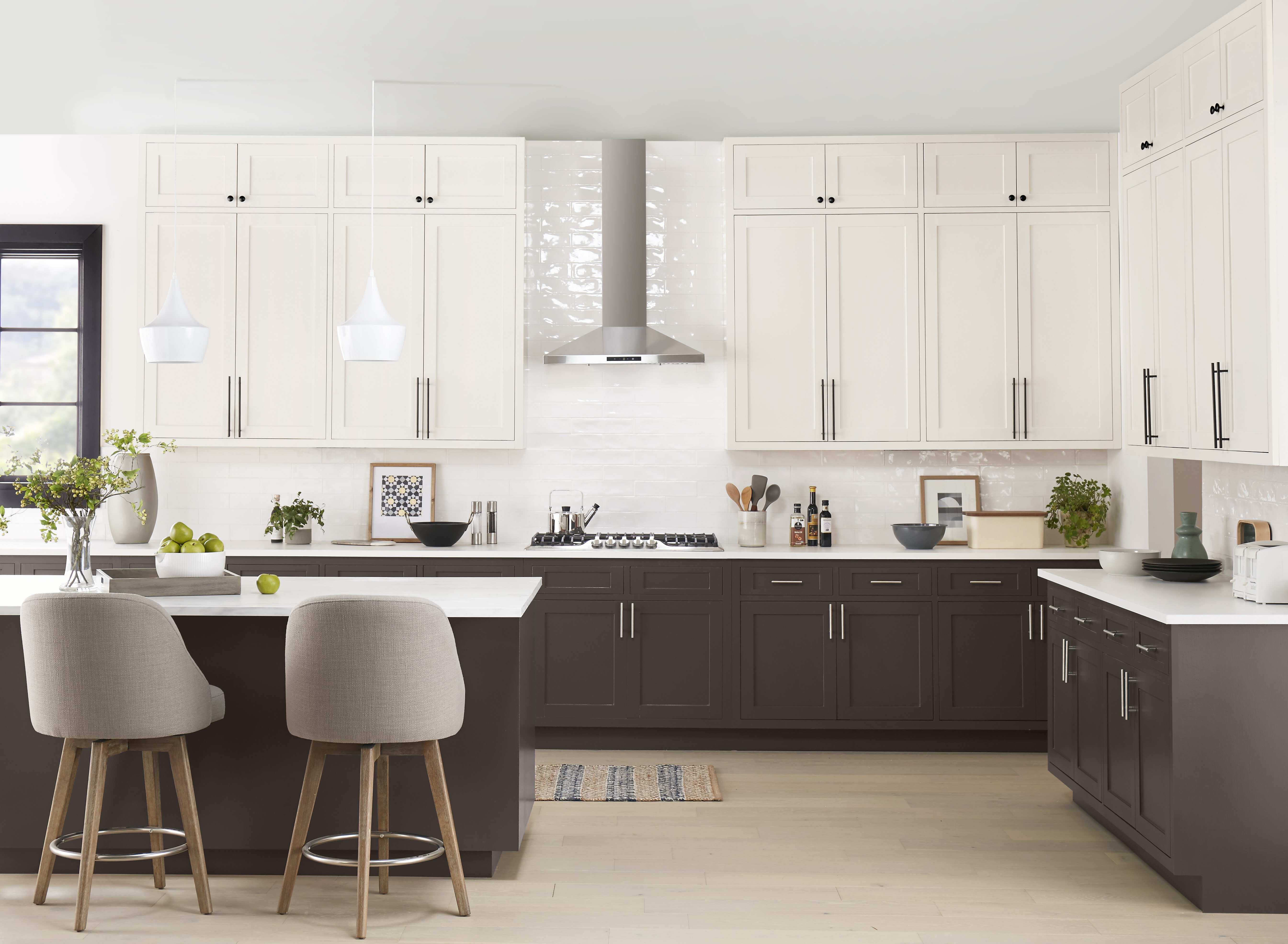 A large traditional kitchen with white upper cabinets and brown lower cabinets and island. 