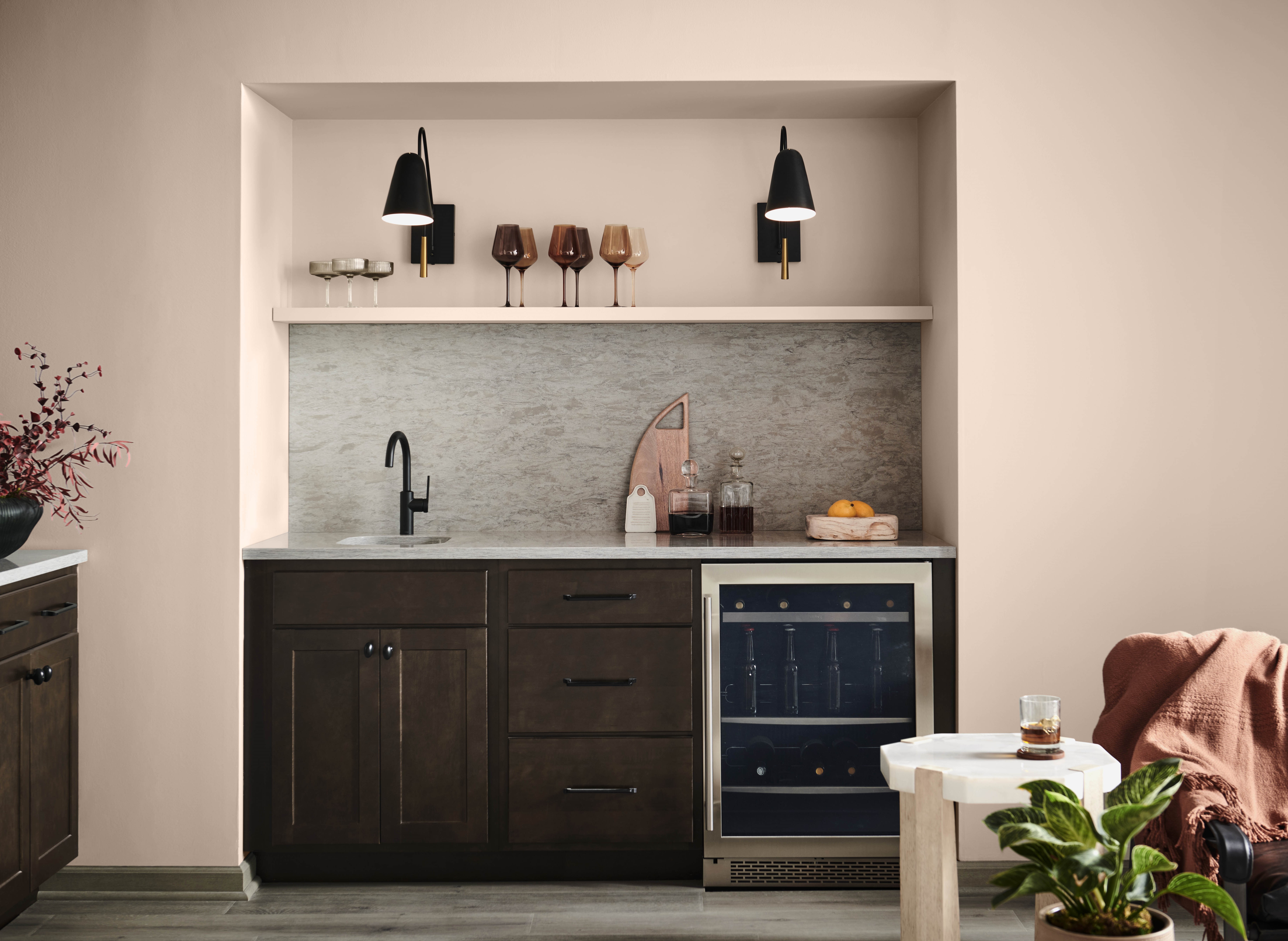 A small home bar nook with walls painted in a pale pink tone called Nutmeg Frost. 